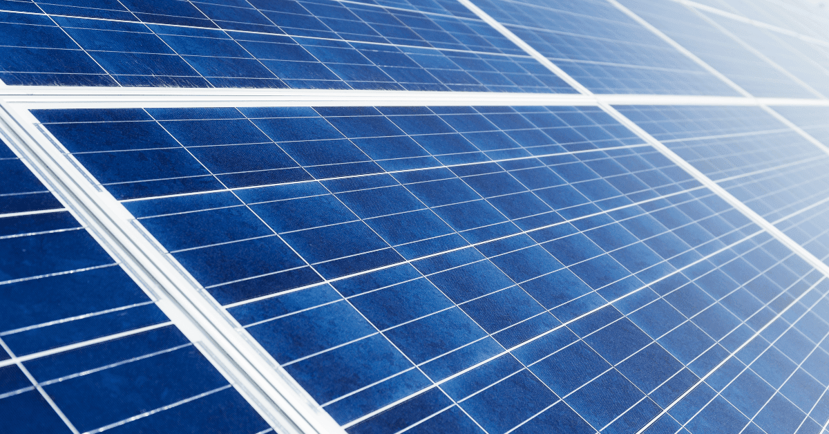 Close-up of blue solar panels with white grid lines angled toward the sun magnitude of the array while tilted in outdoor light.
