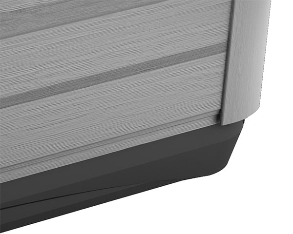 Close-up of the bottom corner of a brushed metal appliance (likely a refrigerator) with a dark plastic kick plate.