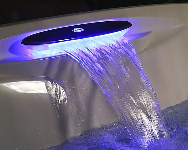 Modern faucet with a blue LED ring pouring a glowing waterfall into a sink or tub basin.