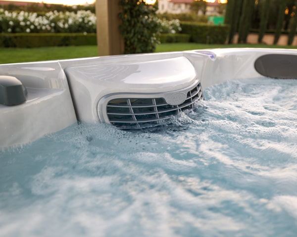 Close-up of a spa jet with bubbles in an outdoor hot tub