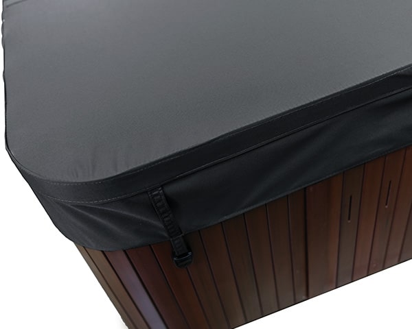 Grey protective cover with a strap fastened over a brown wooden outdoor storage box.