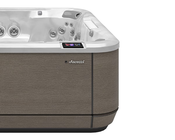 Corner view of a beige textured hot tub with white interior and multiple jets, featuring a digital control panel on the side.