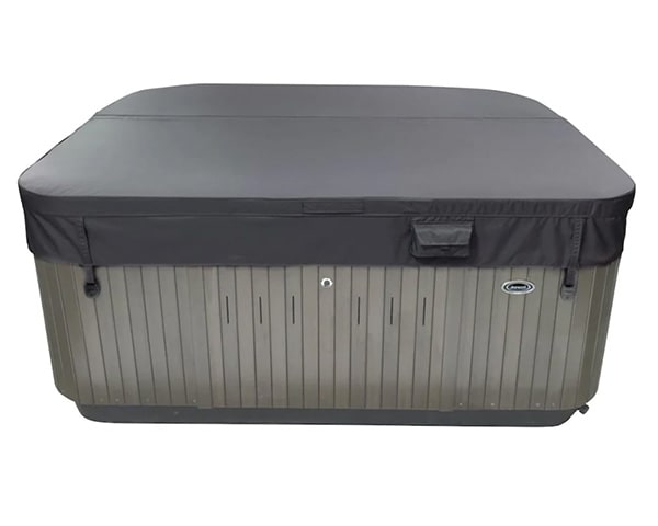 Rectangular outdoor hot tub with a dark protective cover and gray paneling on the sides.