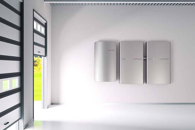 Three silver electrical panels mounted on a white wall in a bright, minimalist utility room